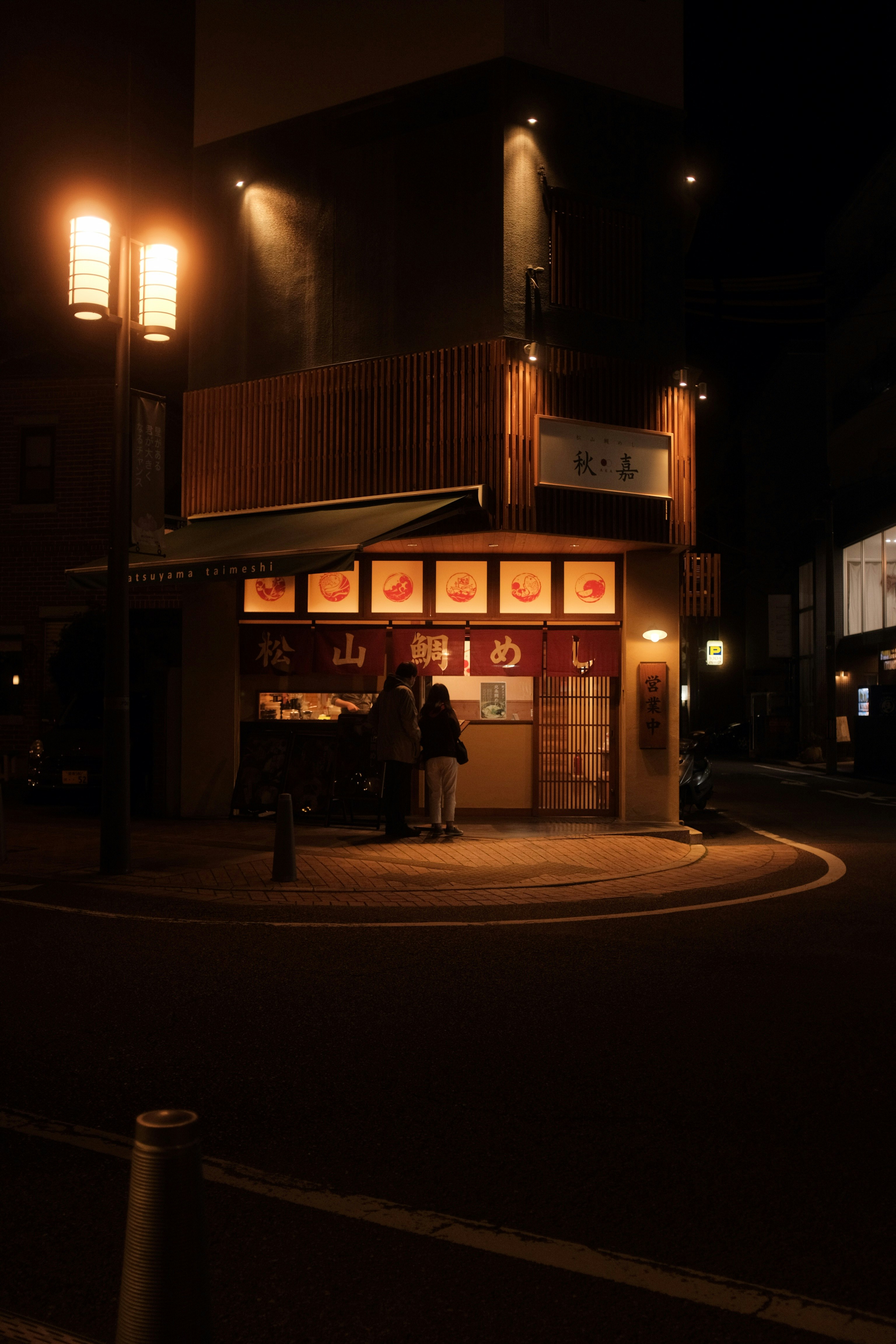 people walking on sidewalk during night time